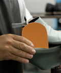 Person holding Ultra Durable Sneaker Heel Pads And Shoe Sole Protector Rubber Anti Slip Heel Repair Pads for boots and sneakers installation.