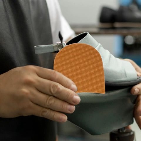 Person holding Ultra Durable Sneaker Heel Pads And Shoe Sole Protector Rubber Anti Slip Heel Repair Pads for boots and sneakers installation.