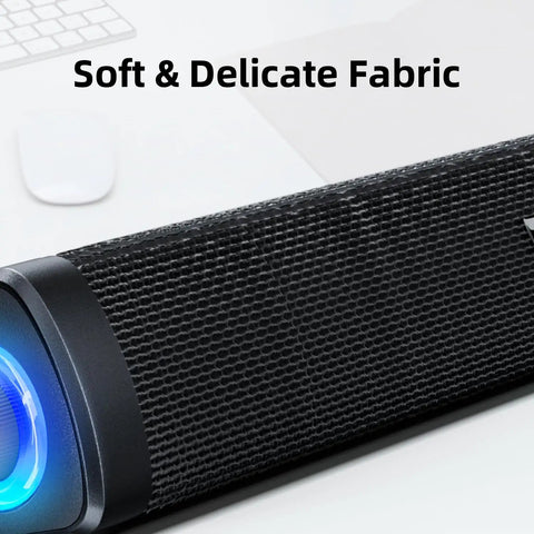 Close-up of USB Computer Speakers With 3.5mm Aux, Wired USB Powered Sound Bar showing fabric texture and blue LED light.