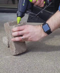 Person using Pro Grade High Temp Hot Glue Gun 220 Watt Heavy Duty Full Size for Industrial Projects on concrete blocks