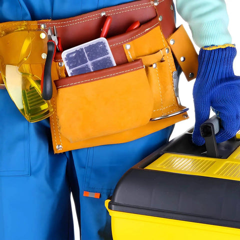 Person in blue coveralls with a tool belt carrying a yellow toolbox