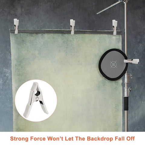 Beastly Grip Heavy Duty 4 Inch Spring Clamps securing backdrop with white protective sleeves in studio setup