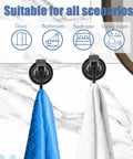 No Drill Wreath Cup Hook With Super Suction Hanger For Kitchen Bath And Restroom Black Plated Polished Finish 4 Pack Damage Free Mount Holds Up To 11 Pounds Easy Install Long Lasting Hold showing two hooks mounted on marble wall holding blue and white towels suitable for various rooms.