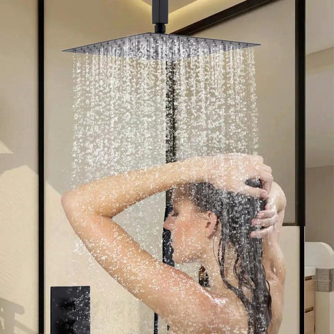 Shower Faucet Set, 12-Inch Rainfall Head, Handheld and Valve, Matte Black with water cascading down over a person.