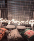 Living The Good Life LED Neon Sign Custom Personalized Home Wall Decor Large 30 Inch Indoor Light with warm white glow on grid.
