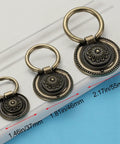 Three sizes of Six Pack Dope Oil Rubbed Bronze Drop Ring Cabinet Handles with Vintage Floral Pattern on blue and white background.