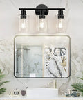 Image of Three Light Matte Black Bathroom Vanity Light Fixtures with Clear Glass Shades installed over a mirror in a bathroom.