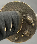 Close-up of Safe Practice Aluminum Iaido Training Sword For Nukitsuke And Noto Drills showing ornate bronze turtle tsuba design.