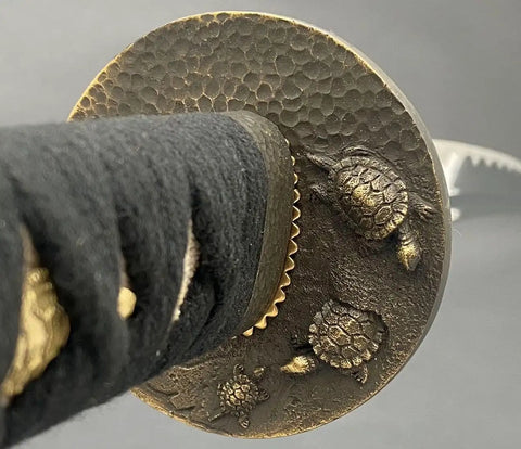 Close-up of Safe Practice Aluminum Iaido Training Sword For Nukitsuke And Noto Drills showing ornate bronze turtle tsuba design.