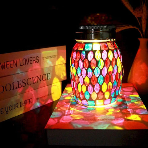 Colorful Outdoor Mosaic Lanterns Solar Powered Hanging Lights illuminating a tabletop, rechargeable mason jar style, warm white glow, waterproof