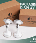 No Sweat Magnetic Door Stoppers 2 Pack Rustproof Stainless Steel Peel Strip displayed with packaging, showcasing white stoppers.