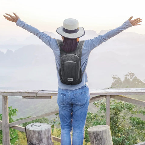 Person wearing Lightweight Packable Hiking Daypack 10L/15L Foldable Outdoor Backpack for travel on scenic overlook