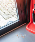 30 Pack Fire Extinguisher Replacement Seals With Tamper Proof Security Pins on a floor near a fire extinguisher.