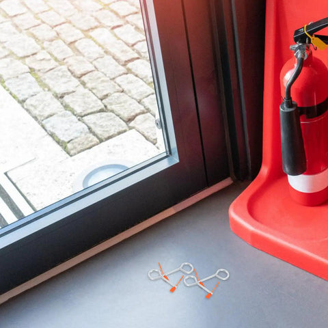 30 Pack Fire Extinguisher Replacement Seals With Tamper Proof Security Pins on a floor near a fire extinguisher.