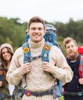 People wearing I Love Camp Pins For Kids 60 Pcs Outdoor Camping Button Accessories on backpacks in a camping setting