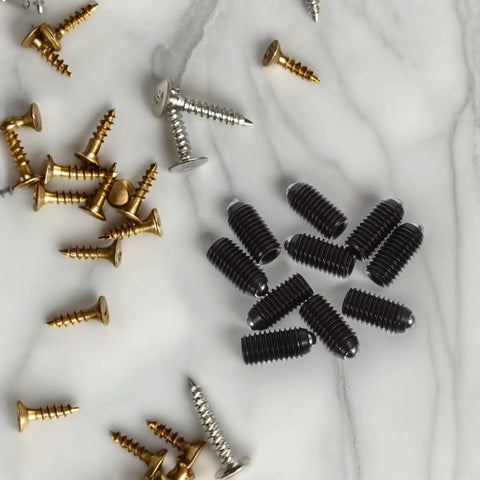 Heavy Duty Carbon Steel Spring Ball Plunger Set Hex Positioning Screws on a marble surface, featuring various screws.