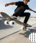 Skateboarder performing trick with Aluminum Skate Bearing Spacers Kit With 16 Pieces 6mm Axle Fits 8mm Bearings visible