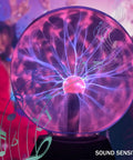 8 Inch Plasma Ball Light Lamp with Touch and Sound Sensitivity, lit globe sending electric streams with musical notes in background.