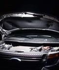 Cordless LED Work Light 4 Pack illuminating car engine under open hood in auto shop.