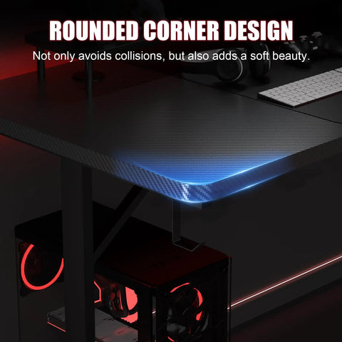 Corner detail of 55 Inch Gaming Desk With LED Lights And Large Mouse Pad For Home Office, showing T Shaped carbon fiber surface and LED glow.
