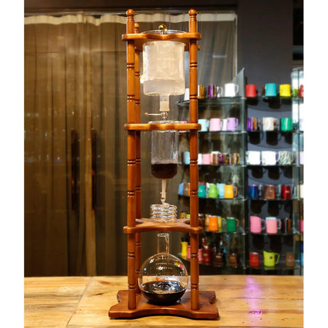 Slick Cold Brew Coffee Tower Featuring A Reliable Ice Drip System For Bold Flavor Kick Holds A Humongous 3000ML Glass Jar Settled On A Raw Brown Wood Stand Perfect For Patio Hangouts Or Friday Night House Vibes