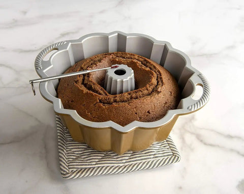 Reusable Bundt Cake Thermometer That Turns Red When Doneness Is Reached inserted in a cake, durable aluminum build, silicone tip cover