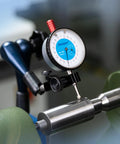 Front view of Dasqua magnetic base indicator holder with blue-dial gauge and swivel clamp mounted on metal shaft