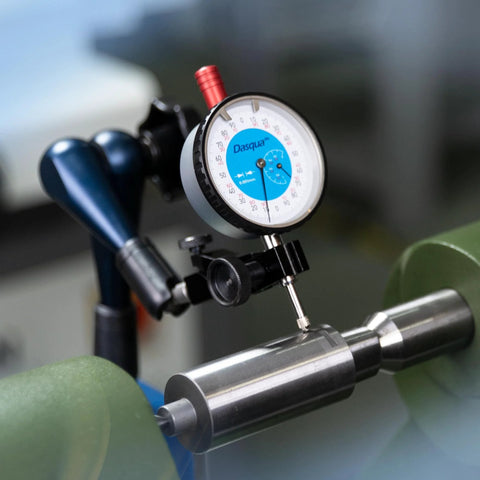 Front view of Dasqua magnetic base indicator holder with blue-dial gauge and swivel clamp mounted on metal shaft