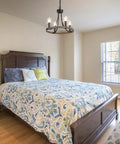 Wagon Wheel Black Farmhouse Chandelier With 4 Lights illuminating a cozy bedroom, featuring rustic decor and wooden bed.