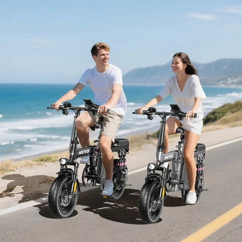 Two people riding 1200W Folding Electric Bike For Adults And Teens, 25 MPH Peak Power, 48V 10Ah Battery, 45 Mile Range by the coast