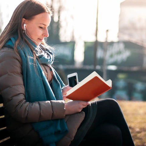 Woman reading Engineer Definition Leather Journal Notebook For Gearheads And Builders in park, wearing earphones.