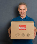 Man holding a box with Fragile Red Shipping Labels With High Visibility And Strong Adhesive on front.
