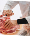2 Pack Cut Resistant Arm Sleeves Hella Tough Pe Guard Top Shelf Protection For Gardening Welding Metalwork And Crafting Keep Your Forearms Beat Proof With Ergonomic Fit And Lightweight Portability For Pros And DIYers worn while slicing meat on a cutting board.