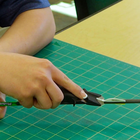 Person using Vane And Wrap Stripping Tool Pro Grade For Arrows With A Sharp Long Lasting Blade Safe Angled Cut Via Preformed Channel