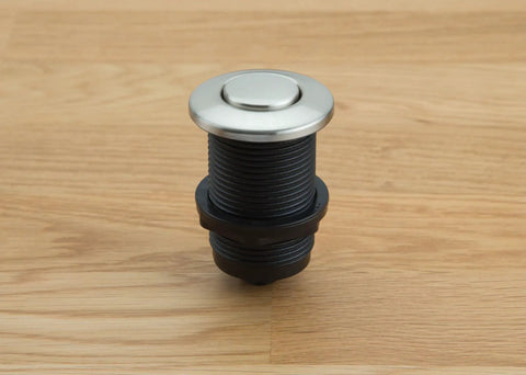 Touch Activated Garbage Disposal Air Switch Kit with metal button on wooden surface