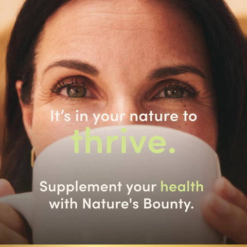 Woman enjoying a drink, promoting health with Nature's Bounty supplements for wellness and vitality.