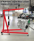 Solid 2 Ton Engine Hoist And Rolling Cherry Picker with reinforced casters lifting an engine in a garage setting.
