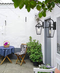 Big Outdoor Wall Lanterns Weatherproof Exterior Light Fixture With Glass Shade Matte Black Finish 21 Inch Wall Mount Porch Light For House Garage Patio Front Door Outdoor Lighting displayed on a white wall next to patio area with flowers.