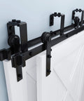 Black 12 Foot Double Track Bypass Sliding Barn Door Hardware Kit installed on white door, showcasing heavy-duty steel and smooth glide