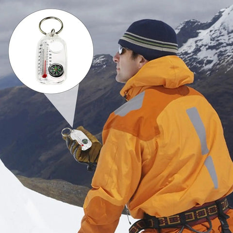 Hiker holding a sturdy outdoor compass keychain for backpacking and travel, pocket size navigation gadget for hiking in snowy mountains.