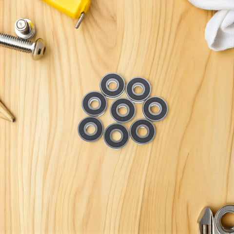 Sick 8 Piece 608RS Black Roller Skate Bearings With Pro Grade Carbon Steel Design For Loud Spins And Low Friction Glide Runs Smooth On Indoor Quads Or Longboards At Night No Grind Resistance Or Squeaky Wheels Ruining Your Ride Quality. 8 black sealed bearings on wood