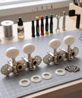 Premium White Ukulele Tuner Pegs And Keys With Smooth Gear Action Compact Metal Alloy Machine Heads on workspace with tools.