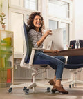 Woman sitting on an office chair with Office Chair Wheels Universal Fit 3 Inch Roller Blade Casters Safe For Hardwood And Carpet Floors