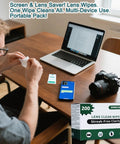 Lens cleaning wipes box, 200-count, green and white packaging, on desk with laptop, camera, and smartphone