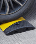 Car wheel on Heavy Duty Rubber Speed Bump 6 Foot Ramp With Integrated Cable Cover 72 Inch Long One Piece Installation Kit Built To Last