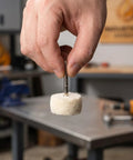 Hand holding a 50 Piece Wool Polishing Buffing Wheel For Drill Attachments with White Cashmere Felt in workshop