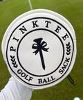 White leather golf valuables pouch with drawstrings, embroidered with graphic and words 'Pink Tee Golf Ball Sack'