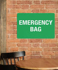 Emergency First Aid Sign For Outdoor Use 8 By 12 Inch Wall Decor on brick wall above wooden chair and table