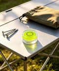 5Pcs Small Circular Bubble Levels with Double Sided Adhesive on a camping table with stakes and a storage pouch.