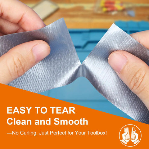 Hands gripping and tearing a roll of Silver Duct Tape, showcasing ease of use with clean tear in a toolbox context.